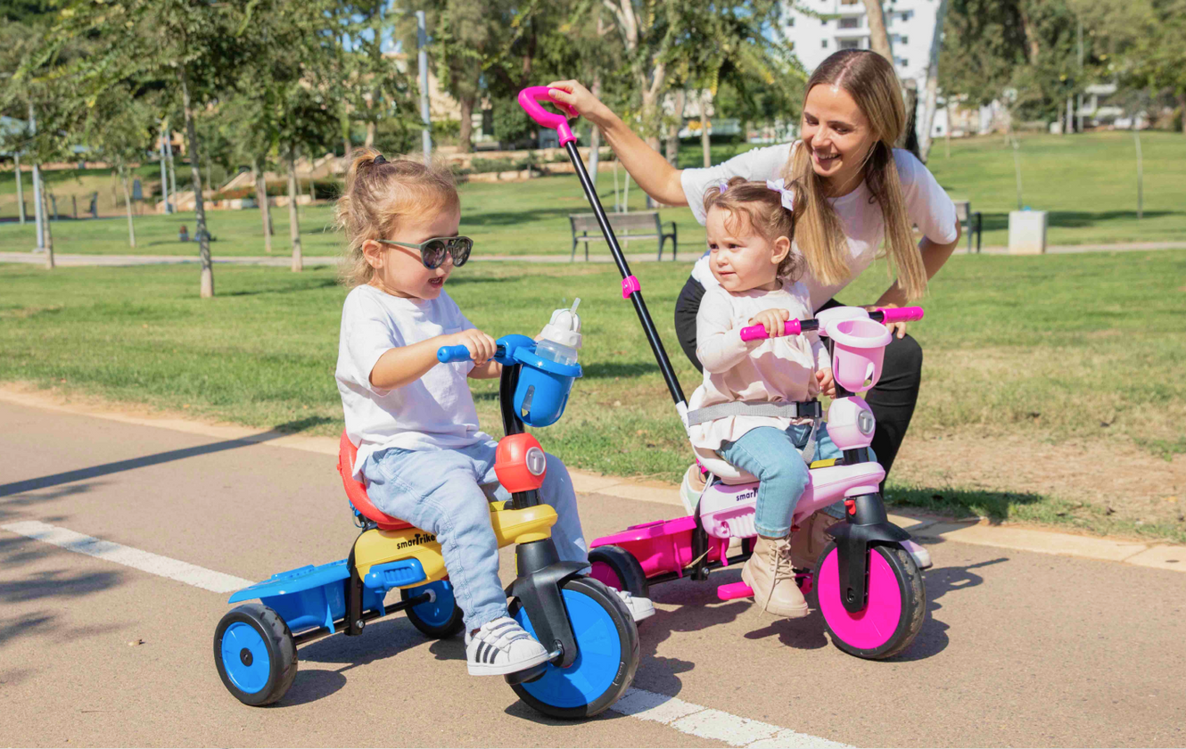 a woman and two children on tricycles