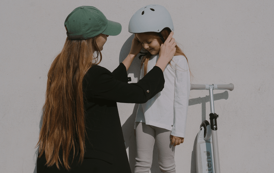 a woman wearing a helmet to a girl